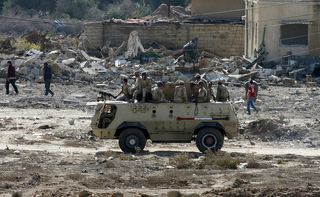 An armoured vehicle of Egyptian army is seen as they blow up buildings as part of an operation aiming to create a buffer zone at the Rafah border in Egypt, on November 1, 2014. After a bombing attack that killed 30 people in the North Sinai region, Egyptian army launched an operation to prevent attacks at the Rafah border which is between Gaza strip and Egypt. (Photo by Abed Rahim Khatib/Anadolu Agency/Getty Images)