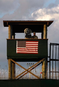 GUANTANAMO BAY, CUBA - MARCH 30:  (EDITORS NOTE: Image has been reviewed by U.S. Military prior to transmission.) A U.S. Army soldier stands watch in a guard tower at Camp Delta in the Guantanamo Bay detention center on March 30, 2010 in Guantanamo Bay, Cuba. U.S. President Barack Obama pledged to close the prison by early 2010 but has struggled to transfer or try the remaining detainees from the facility, located on the U.S. Naval Base at Guantanamo Bay, Cuba.  (Photo by John Moore/Getty Images)