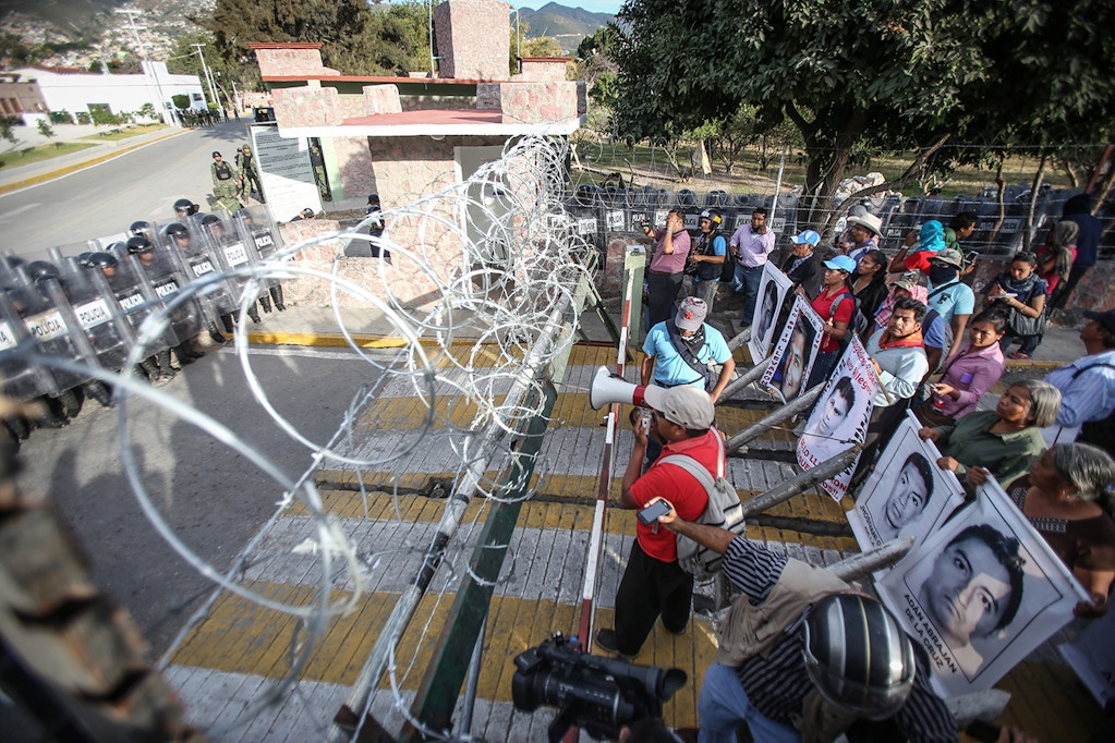 IGUALA, MEXICO - JANUARY 12: Protestors demanding justice and clarification of the disappearance of 43 students from Ayotzinapa stage clash with police in front of the 27th infantry battalion headquarters in Iguala, Mexico on January 12, 2015. Trucks are damaged and set on fire during protest. (Photo by Eric Chavelas Hernandez/Anadolu Agency/Getty Images)