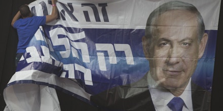 TEL AVIV, ISRAEL - MARCH 17:  An Israeli man hangs a poster of  Prime Minister Benjamin Netanyahu at his election campaign headquarters on election day on March 17, 2015 in Tel Aviv, Israel. Israel's general election voting has begun today as polls show on that Chairman of the Zionist Union party, Isaac Herzog stands as the only rival to current Prime Minister Benjamin Netanyahu.  (Photo by Lior Mizrahi/Getty Images)