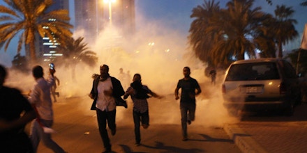 MANAMA, BAHRAIN - FEBRUARY 18:  Protesters run from a cloud of teargas during a clash with Bahraini security forces near the Pearl roundabout on February 18, 2011 in Manama, Bahrain. Protesters said that the army fired on them with live rounds, followed by teargas which drove the demonstrators back. There are unconfirmed reports that there are four dead in the clashes.  (Photo by John Moore/Getty Images)
