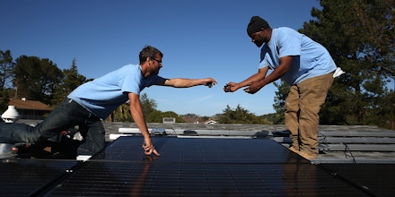 SAN RAFAEL, CA - FEBRUARY 26:  SolarCraft workers Craig Powell (L) and Edwin Neal install solar panels on the roof of a home on February 26, 2015 in San Rafael, California. According to a survey report by the Solar Foundation, the solar industry employs more workers than coal mining with nearly 174,000 people working in solar compared to close to 80,000 mining coal.  (Photo by Justin Sullivan/Getty Images)