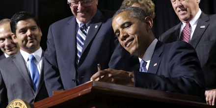 President Barack Obama, flanked by Senate Veterans Affairs Committee Chairman Sen. Bernie Sanders, I-Vt., left, and House Minority Whip Steny Hoyer of Md., right, signs H.R. 3230, the Veterans' Access to Care through Choice, Accountability, and Transparency Act of 2014, at the Wallace Theater in Fort Belvoir, Va. on Thursday, Aug. 7, 2014. The bill gives resources to the Department of Veterans Affairs to improve access and quality of care for veterans. (AP Photo/Jacquelyn Martin)