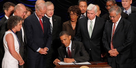 FILE - In this July 21, 2010, file photo President Barack Obama signs the Dodd-Frank Wall Street Reform and Consumer Protection financial reform bill at the Ronald Reagan Building in Washington. For decades presidents of both parties have let autopens do some of the heavy lifting when it comes to signing their signatures. But apparently a first in May 2011 Obama, overseas and out of reach, instructed his Washington staff to use one to sign a bill into law. With Obama from left are Treasury Secretary Timothy Geithner, teacher Robin Fox, Vietnam veteran Andrew Giordano, House Speaker Nancy Pelosi, D-Calif., Vice President Joe Biden, Senate Majority Leader Harry Reid D-Nev., Rep. Maxine Waters, D-Calif., Rep. Mel Watt, D-N.C., Sen. Chris Dodd, D-Conn., Rep. Gregory Meeks, D-N.Y., Rep. Barney Frank, D-Mass., and Rep. Dennis Moore, D-Kan. (AP Photo/Charles Dharapak, File)