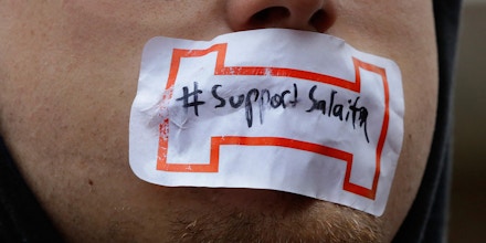 Students tape their mouths shut in support for Steve Salaita, a professor who lost a job offer from the University of Illinois over dozens of profane Twitter messages that critics deemed anti-Semitic, during a rally at the University of Illinois campus Tuesday, Sept.  9, 2014, in Champaign Ill. (AP Photo/Seth Perlman)