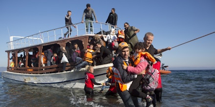 Greek and Norwegian volunteers help a boat full of Syrian refugees to disembark after arriving on the  sea-shore at the north part of Lesvos island, Greece after crossing the  Aegean Sea from Turkey ovember 12 ,2015. The  small Greek island of Lesvos ,once known as a  tourist destination has now become  the center of the European refugee crisis .(Photo by Heidi Levine/Sipa Press).