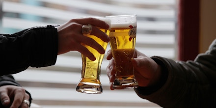 Two men make a toast prior to drink a beer at a bar table on March 10, 2015 in Pont-Audemer, northwestern France. AFP PHOTO/CHARLY TRIBALLEAU.        (Photo credit should read CHARLY TRIBALLEAU/AFP/Getty Images)