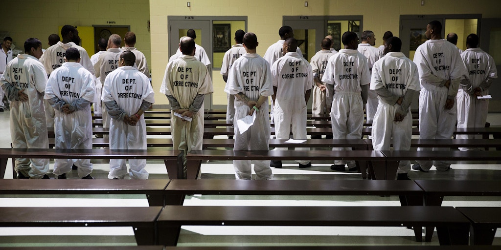 Prisoners stand while being processed for intake at the Georgia Diagnostic and Classification Prison Tuesday, Dec. 1, 2015, in Jackson, Ga. They arrive by the busload each Tuesday and Thursday, dozens of new inmates entering Georgia’s prison system. Most stay only a week or two. But for those sentenced to die, this is their last stop. (AP Photo/David Goldman)