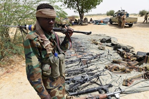 A Chadian soldier stand guard next to captured arms on April 3, 2015 in Malam Fatori, in northeastern Nigeria, which was retaken from Islamist Boko Haram militants by troops from neighbouring Chad and Niger. Soldiers from Chad and Niger on April 1, drove Boko Haram Islamist militants from the border town that was one of the insurgency's last footholds in northeastern Nigeria.  AFP PHOTO/PHILIPPE DESMAZES        (Photo credit should read PHILIPPE DESMAZES/AFP/Getty Images)