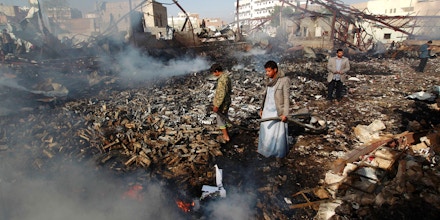 Yemeni men inspect the damage at the site of a Saudi-led coalition air strike which hit a sewing workshop, in the capital Sanaa, on February 14, 2016.The factory owner, Faisal al-Musaabi, told AFP that 