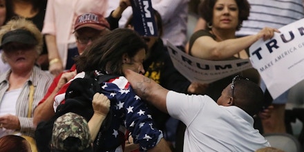 Trump protester Bryan Sanders, center left, is punched by a Trump supporter as he is escorted out of Republican presidential candidate Donald Trump's rally at the Tucson Arena in downtown Tucson, Ariz., Saturday, March 19, 2016. (Mike Christy/Arizona Daily Star via AP) MANDATORY CREDIT