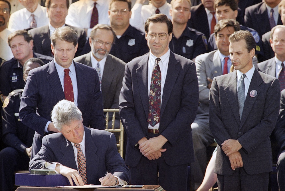 President Bill Clinton signs the $30 billion crime bill during a ceremony on the South Lawn of the White House in Washington on Sept. 13, 1994. Looking on, from left: Vice President Al Gore; House Majority Whip David Bonior of Mich.; Stephen Sposato, whose wife was killed by a gunman invaded the San Francisco law firm where she worked; Rep. Bill Richardson, D-N.M.; and Marc Klass, whose daughter Polly was kidnapped and killed. (AP Photo/Denis Paquin)