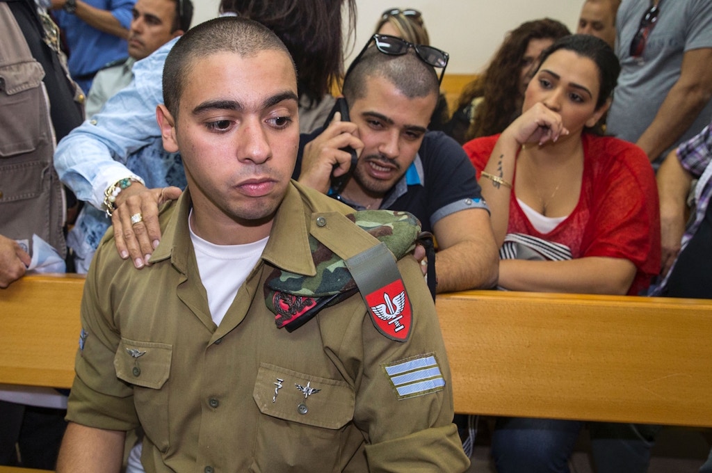 Israeli soldier Elor Azaria, who was caught on video shooting a wounded Palestinian assailant in the head as he lay on the ground, sits during a hearing at a military appeals court in Tel Aviv during which he was charged with manslaughter on April 18, 2016.Prosecutors presented the indictment to a military court over the March 24 killing, which occurred minutes after the Palestinian had stabbed another soldier and lay prone on the ground wounded by gunfire, according to Israeli authorities. He was also charged with conduct unbecoming of his rank and position in the army. / AFP / JACK GUEZ (Photo credit should read JACK GUEZ/AFP/Getty Images)