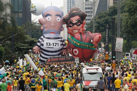 Demonstrators parade large inflatable dolls depicting Brazil's former President Luiz Inacio Lula da Silva in prison garb and current President Dilma Rousseff dressed as a thief, with a presidential sash that reads "Impeachment," in Sao Paulo, Brazil, Sunday, March 13, 2016. The corruption scandal at the state-run oil giant Petrobras has ensnared key figures from Rousseff’s Workers’ Party, including her predecessor and mentor, Lula da Silva, as well as members of opposition parties. (AP Photo/Andre Penner)