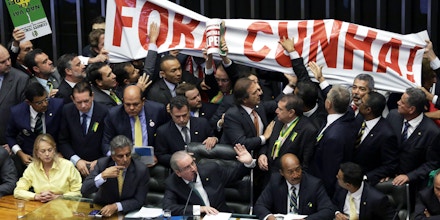 Pro-government deputies hold a banner that reads in Portuguese 