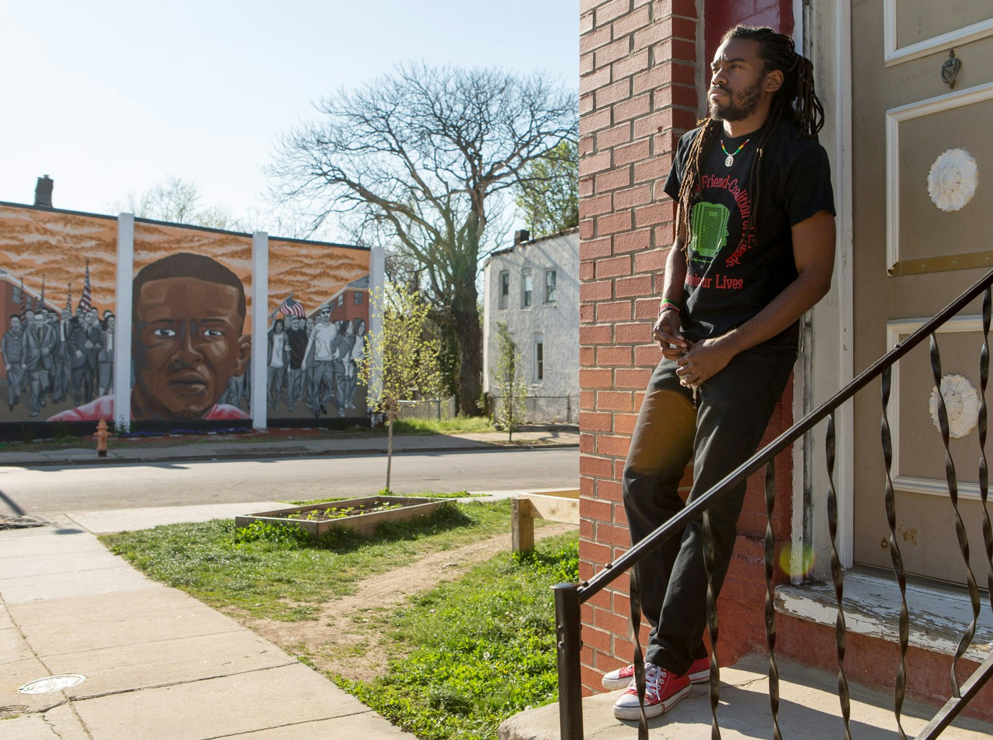 Attorney and activist Taalib Saber poses for a photo outside a house that is across the street from where Freddie Gray, who died while in police custody just over one year ago, was picked up by police in Baltimore, Maryland, April 23, 2016. Saber is using the home, which he found vacant, for children's community activities. (photo by Allison Shelley)