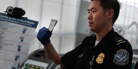 NEWARK, NJ - AUGUST 24:  A traveler arriving from overseas is fingerprinted (L) while his paperwork is checked by a border patrol official (R) at the passport control line in Newark International Airport August 24, 2009 in Newark, New Jersey.  Officials with U.S. Customs and Border Protection are introducing are introducing the Global Entry program, which allows pre-screening and approval of travelers and faster trips through customs and passport lines upon arriving into the United States.  (Photo by Chris Hondros/Getty Images)