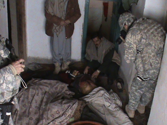 An U.S. soldier takes photograph of an Afghan man inside a room where five members of  an Afghan family were killed near Gardez, in Paktia province, south east Afghanistan, Friday, Feb. 12, 2010.  Afghan officials in Paktia province confirmed Friday they are investigating the deaths of five people in a home near the provincial capital of Gardez.  Police Chief Gen. Azizudin Wardak said the five  two men and three women were killed Thursday night during a party. (AP Photo)