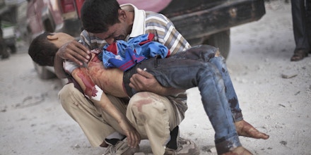 FILE - A Syrian man cries while holding the body of his son, killed by the Syrian Army, near Dar El Shifa hospital in Aleppo, Syria, Wednesday, Oct. 3, 2012. (AP Photo/Manu Brabo, File)