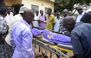 Relatives and other mourners watch as the body of South Sudanese journalist Peter Julius Moi is taken into the mortuary in Juba, South Sudan Thursday, Aug. 20, 2015. The father of Moi, a reporter for the Corporate Weekly, says unknown gunmen shot his son twice in the back and killed him late Wednesday, Aug. 19, 2015 on the outskirts of the capital Juba, in an attack that came days after President Salva Kiir was reported to have threatened to kill reporters "working against the country." (AP Photo/Jason Patinkin)