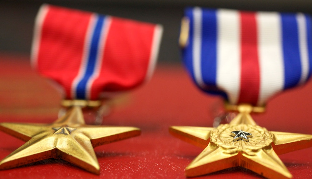 The Bronze and Silver Star sit on display at an award ceremony where they will be presented to Marines with Marine Corps Forces Special Operations Command at Camp Pendleton, Calif., March 12. Staff Sgt. Andrew K. Thompson received the military’s third highest award, the Silver Star. Staff Sgt. Maurice Scott received the fourth highest award, the Bronze Star, at Camp Pendleton, Calif., March 12. Thompson, from Bismark, N.D., led Marines and Afghans successfully into an attack under intense fire to overcome the enemy, according to the citation. Scott, 33, from Chicago, employed supporting aircraft to break lines and hinder enemy activity during a night helicopter raid, according to the citation.