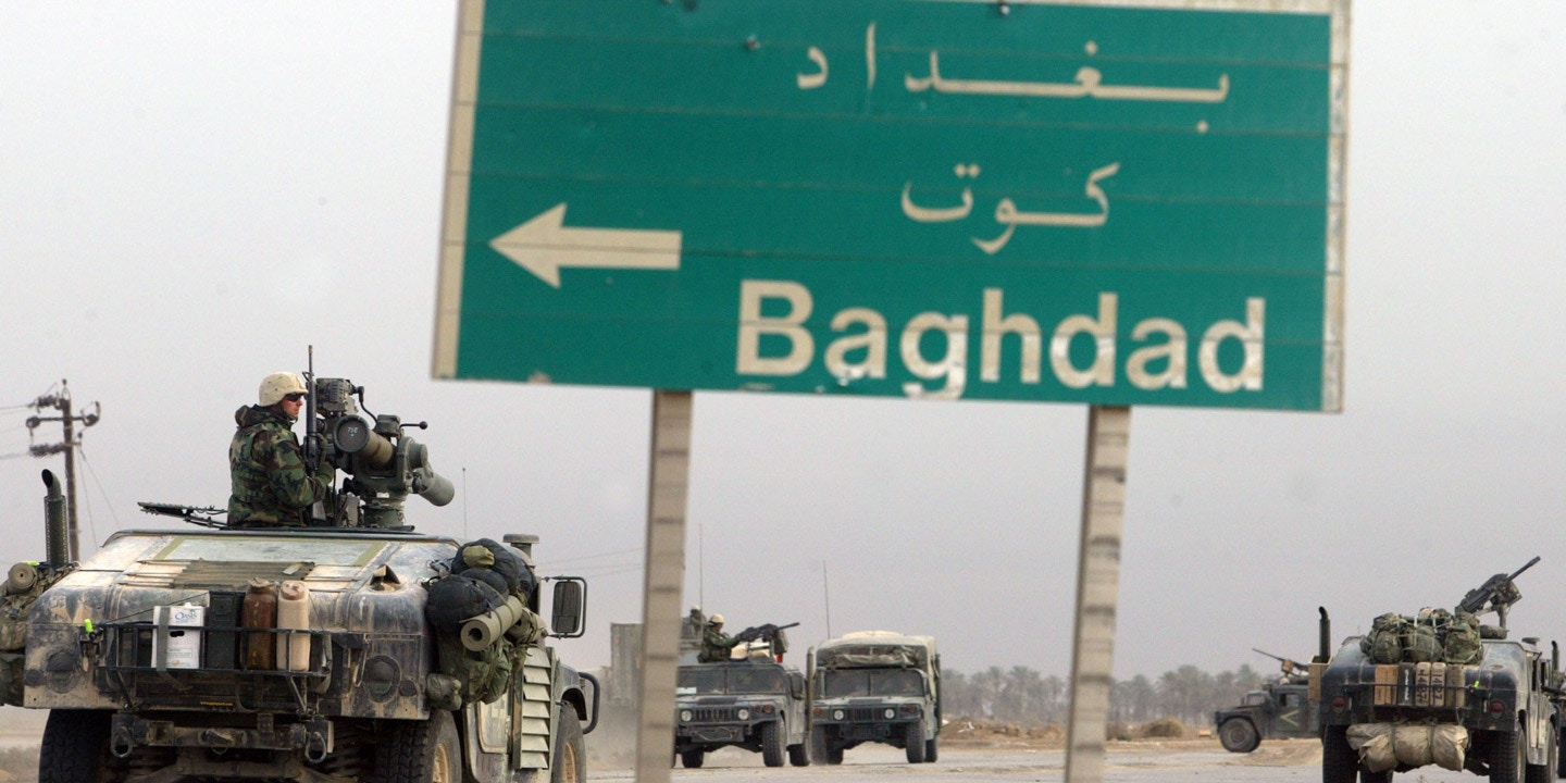 NASIRIYAH, IRAQ - MARCH 25:  U.S. Marines from the 1st Marine Division pass a sign pointing the way to Baghdad as they continue their march to the capital March 25, 2003 in the southern Iraqi city of Nasiriyah. After two days of running gun battles, the third day seems to be relatively quiet.  (Photo by Joe Raedle/Getty Images)