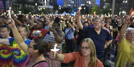 People hold candles during a vigil for the victims of the Pulse nightclub shooting, on June 13, 2016 at the Dr. Phillips Center for the Performing Arts in Orlando, Florida.The American gunman who launched a murderous assault on a gay nightclub in Orlando was radicalized by Islamist propaganda, officials said Monday, as they grappled with the worst terror attack on US soil since 9/11. / AFP / MANDEL NGAN (Photo credit should read MANDEL NGAN/AFP/Getty Images)