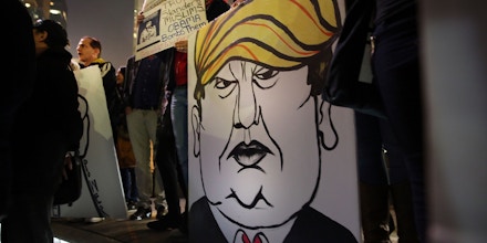 NEW YORK, NY - DECEMBER 10: A protester holds a caricature of conservative presidential candidate Donald Trump during a demonstration against racism and Trump's recent remarks concerning Muslims on December 10, 2015 in New York City. Dozens or demonstrators and activists converged at Columbus Circle to denounce the politics of Trump and the treatment of Muslim refugees both in America and Europe.  (Photo by Spencer Platt/Getty Images)