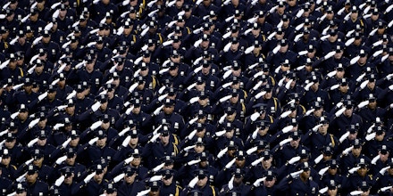 Graduating officers with the  New York Police Department 2016  graduation class salute during a ceremony at Madison Square Garden July, 1, 2016. / AFP / TIMOTHY A. CLARY        (Photo credit should read TIMOTHY A. CLARY/AFP/Getty Images)