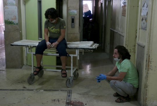 Hospital workers react after a barrel bomb struck just outside the Omar bin Abdaziz hospital in the Maadi district of the northern Syrian city of Aleppo following government air raids on rebel-held districts of the city on July 16, 2016. Air raids on rebel-held districts of Syria's battleground second city of Aleppo killed at least 21 civilians including children, the Syrian Observatory for Human Rights said. / AFP / THAER MOHAMMED (Photo credit should read THAER MOHAMMED/AFP/Getty Images)