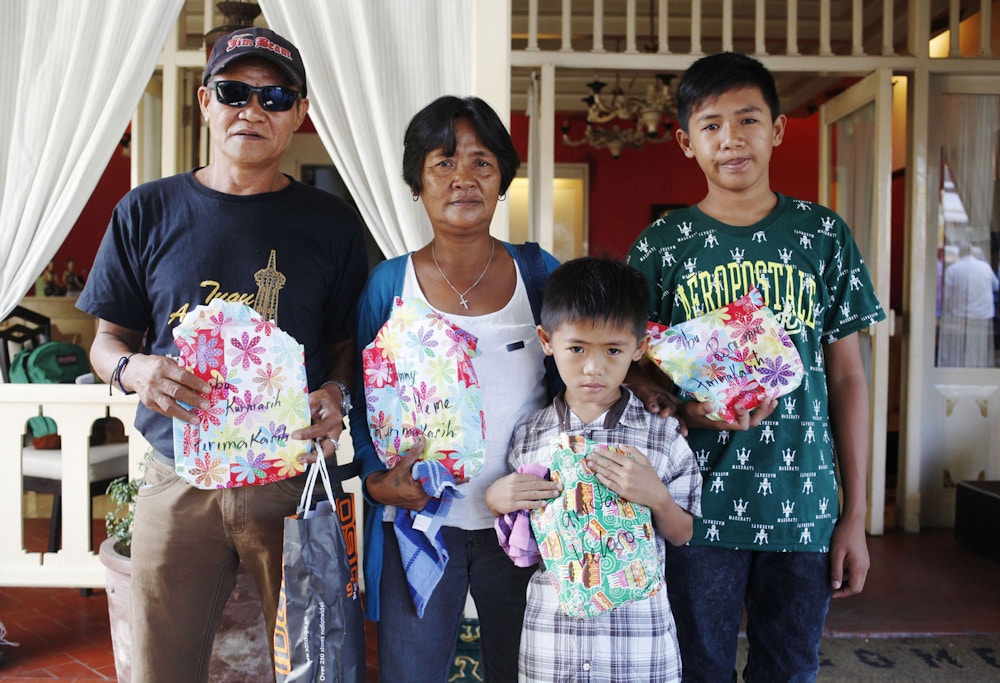 Family members of Philippine death row drug convict Mary Jane Veloso, (L-R) father Caesar Veloso, mother Celia Veloso and sons Mark Darren and Mark Danniel show the press presents they brought as they wait outside the Yogyakarta prison, in Yogyakarta on January 12, 2016, before visiting Mary to celebrate her 31st birthday. Veloso was sentenced to death in Indonesia after being arrested in 2009 with 2.6 kilograms (5.7 pounds) of heroin sewn into the lining of her suitcase. She had been due to face the firing squad along with other foreign drug convicts in April but was granted a temporary reprieve after a woman suspected of recruiting her was arrested in the Philippines. AFP PHOTO / Suryo WIBOWO / AFP / SURYO WIBOWO        (Photo credit should read SURYO WIBOWO/AFP/Getty Images)