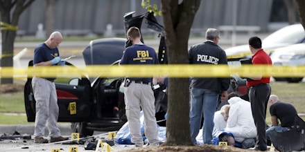FBI crime scene investigators document the area around two deceased gunmen and their vehicle outside the Curtis Culwell Center in Garland, Texas, Monday, May 4, 2015. Police shot and killed the men after they opened fire on a security officer outside the suburban Dallas venue, which was hosting provocative contest for Prophet Muhammad cartoons Sunday night, authorities said. (AP Photo/Brandon Wade)