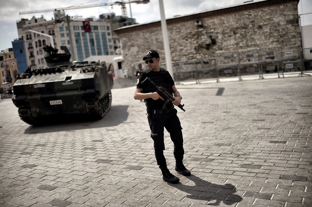 A police officer stands next to an armoured vehicle that was used by soldiers during the coup attempt at Taksim square in Istanbul on July 17, 2016. Turkish President Recep Tayyip Erdogan vowed on July 17 to purge the "virus" within state bodies, during a speech at the funeral of victims killed during the coup bid he blames on his enemy Fethullah Gulen. / AFP / ARIS MESSINIS (Photo credit should read ARIS MESSINIS/AFP/Getty Images)