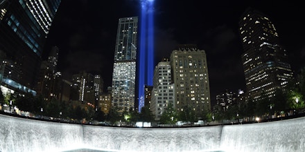 The Tribute in Light illuminates the sky  behind the  9/11 Memorial waterfalls and reflecting pool in New York on September 10, 2014, the night before the 13th anniversary of the September 11, 2001 attacks. The tribute, an art installation of the Municipal Art Society, consists of 88 searchlights placed next to the site of the World Trade Center creating two vertical columns of light in remembrance of the 2001 attacks. AFP PHOTO /  TIMOTHY  A. CLARY        (Photo credit should read TIMOTHY A. CLARY/AFP/Getty Images)
