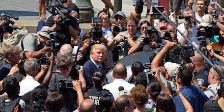 US presidential candidate Donald Trump(C) is mobbed by the media as he exits New York Supreme Court after morning jury duty August 17, 2015 in New York.  Trump reported for jury duty in New York on Monday, stepping out of a sleek black limo to be mobbed by media and supporters. The bombastic real estate magnate, who is leading the polls among 17 Republican candidates for president, arrived at New York State Supreme Court at 9:08 am (1308 GMT) dressed in a blue suit and striped tie. He strode up the sweeping steps of the court house surrounded by a phalanx of police, television cameras, journalists and photographers, signing an autograph for one fan and fist-bumping another.  AFP PHOTO/DON EMMERT        (Photo credit should read DON EMMERT/AFP/Getty Images)