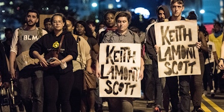 CHARLOTTE, NC - SEPTEMBER 22: Demonstrators march during protests September 22, 2016 in Charlotte, North Carolina. Protests began on Tuesday night following the fatal shooting of 43-year-old Keith Lamont Scott at an apartment complex near UNC Charlotte. A state of emergency was declared overnight in Charlotte and a midnight curfew was imposed by mayor Jennifer Roberts, to be lifted at 6 a.m. (Photo by Sean Rayford/Getty Images)