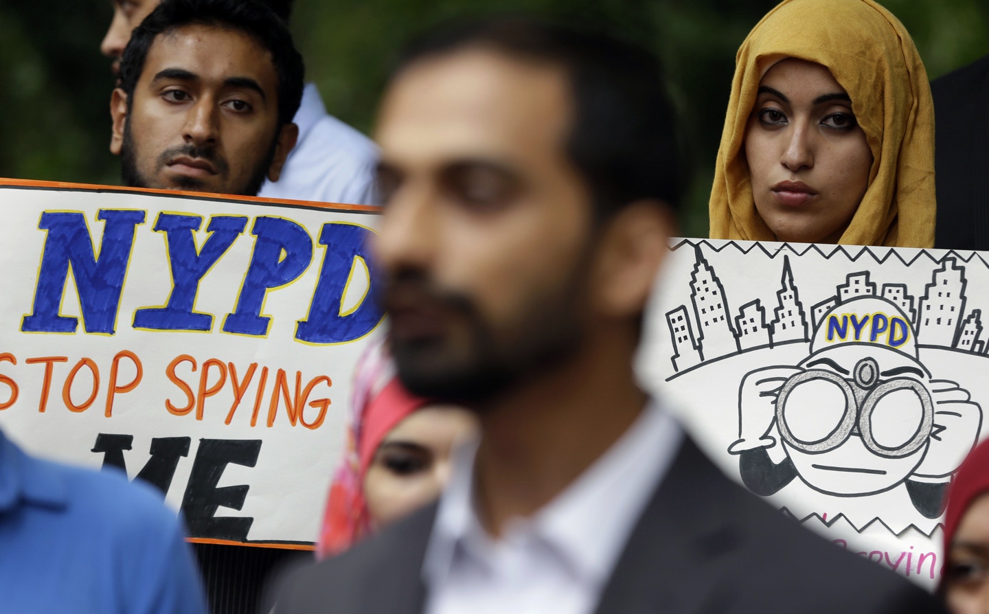 People hold signs while attending a rally to protest New York Police Department surveillance tactics near police headquarters in New York, Wednesday, Aug. 28, 2013. The New York Police Department has secretly labeled entire mosques as terrorist organizations, a designation that allows police to use informants to record sermons and spy on imams, often without specific evidence of criminal wrongdoing. (AP Photo/Seth Wenig)