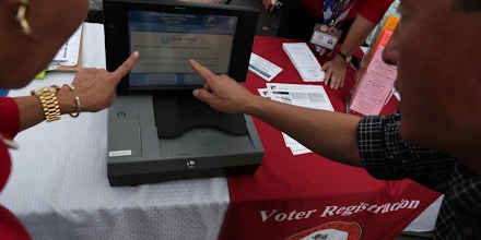 TYSONS CORNER, VA - OCTOBER 02:  Virginia State House Delegate Mark Keam (R) watches a demonstration of a voting machine by a staff of Fairfax County Office of Elections during the annual KORUS festival, a Korean cultural festival, October 2, 2016 in Tysons Corner, Virginia. It has been reported that the voter registration systems of more than 20 states were targeted by hackers in recent months.  (Photo by Alex Wong/Getty Images)