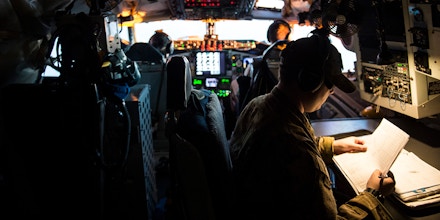 U.S. Air Force Senior Airman Ryan Thayer looks over flight paperwork while flying on a KC-135 Stratotanker over Iraq, March 17, 2016, in support of Operation Inherent Resolve. Thayer is a boom operator deployed out of the 344th Air Refueling Squadron at McConnell Air Force Base, Kan. (U.S. Air Force photo by Staff Sgt. Corey Hook/Released)