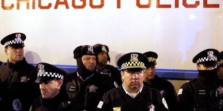 CHICAGO, IL - DECEMBER 18 : Chicago police officers surround a police vehicle as they watch demonstrators protesting the fatal police shooting of Laquan McDonald December 18, 2015 in Chicago, Illinois. Former Chicago police officer Jason Van Dyke, who was charged with murder last month in the shooting death of 17-year-old McDonald last year, was indicted on six counts of first-degree murder and one count of official misconduct earlier this week. (Photo by Joshua Lott/Getty Images)