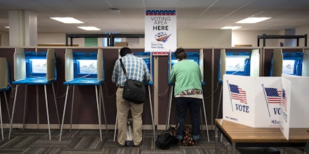 Joseph and Maria Caruso vote inside the Early Vote Center in downtown Minneapolis, Minnesota after work on October 5, 2016.Voters in Minnesota can submit their ballot for the General Election at locations across the state every day until Election Day on November 8, 2016. / AFP / STEPHEN MATUREN (Photo credit should read STEPHEN MATUREN/AFP/Getty Images)