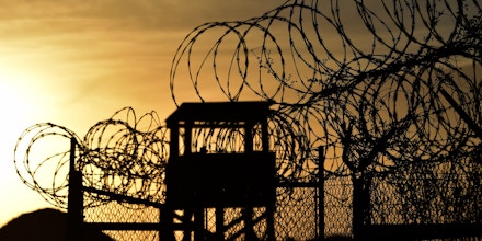 This photo made during an escorted visit and reviewed by the US military, shows the razor wire-topped fence and a watch tower at the abandoned 