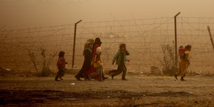 TOPSHOT - Syrian children walk around the camp grounds during a sandstorm at a temporary refugee camp in the village of Ain Issa, housing people who fled Islamic State group's Syrian stronghold Raqa, some 50 kilometres (30 miles) north of the group's de facto capital on November 10, 2016.The US-backed Syrian Democratic Forces (SDF) said their advance on Raqa was being held back by a sandstorm that had hit the desert province. Speaking in Ain Issa, the main staging point for the operation some 50 kilometres (30 miles) north of Raqa, the commander said the sandstorm was also impeding visibility for coalition warplanes. / AFP / DELIL SOULEIMAN (Photo credit should read DELIL SOULEIMAN/AFP/Getty Images)