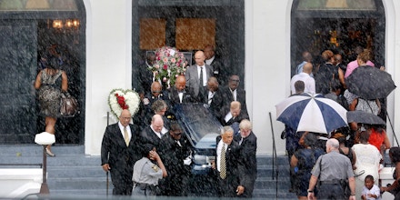 Rain falls as pallbearers exit Emanuel AME Church carrying the casket of Cynthia Hurd as mourners for Susie Jackson and Tywanza Sanders file inside the church for their funerals Saturday, June 27, 2015, in Charleston, S.C. Hurd, Jackson and Sanders were three of the nine people killed in the shooting at the church on June 17. (Grace Beahm/The Post And Courier via AP)