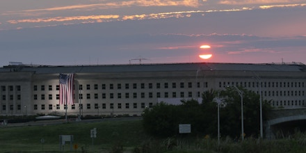 ARLINGTON, VA - SEPTEMBER 11: In this U.S. Navy handout, sunrise at the Pentagon prior to a ceremony to commemorate the 15th anniversary of the Sept. 11, 2001 terror attacks. The American flag is draped over the site of impact at the Pentagon.  In 2008, the National 9/11 Pentagon Memorial opened  adjacent to the site, located on Boundary Channel Drive in Arlington, Va., and commemorates the 184 lives lost at the Pentagon and onboard American Airlines Flight 77 during the terrorist attacks. (Photo by Damon J. Moritz/Released via Getty Images)