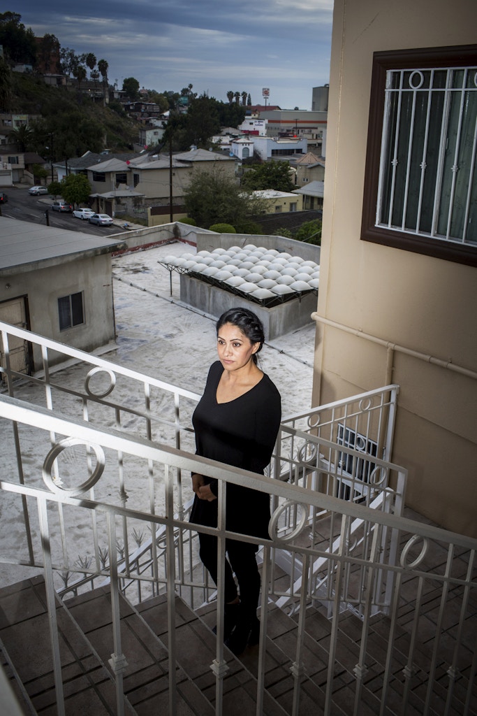 TIJUANA, MX. - APRIL 7 2016:  Maria de la Luz Montalvo poses for a portrait on the stairways of her Tijuana apartment building. Also a Dreamer Mom, she was deported from the US nearly 6 years ago. Her husband and the father of her children, a US Citizen, abused her, a story common among Dreamer Moms who often have no legal recourse to take if their husband is a citizen, and she suspects that he was ultimately responsible for her deportation. He does not allow her to speak to her children on the phone and has only allowed them to visit her once. </p><br /><br /><br /><br /><br /> <p>Natalie Keyssar