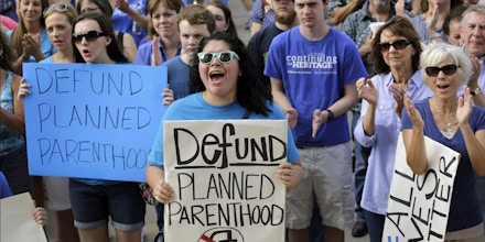 FILE- In this July 28, 2015 file photo, Erica Canaut, center, cheers as she and other anti-abortion activists rally on the steps of the Texas Capitol in Austin, Texas, to condemn the use in medical research of tissue samples obtained from aborted fetuses. Texas is moving forward with booting Planned Parenthood from Medicaid despite federal judges stopping other Republican-controlled states from doing the same. But a string of recent victories for the nation's largest abortion provider will be tested in 2017 under a new president. (AP Photo/Eric Gay, File)