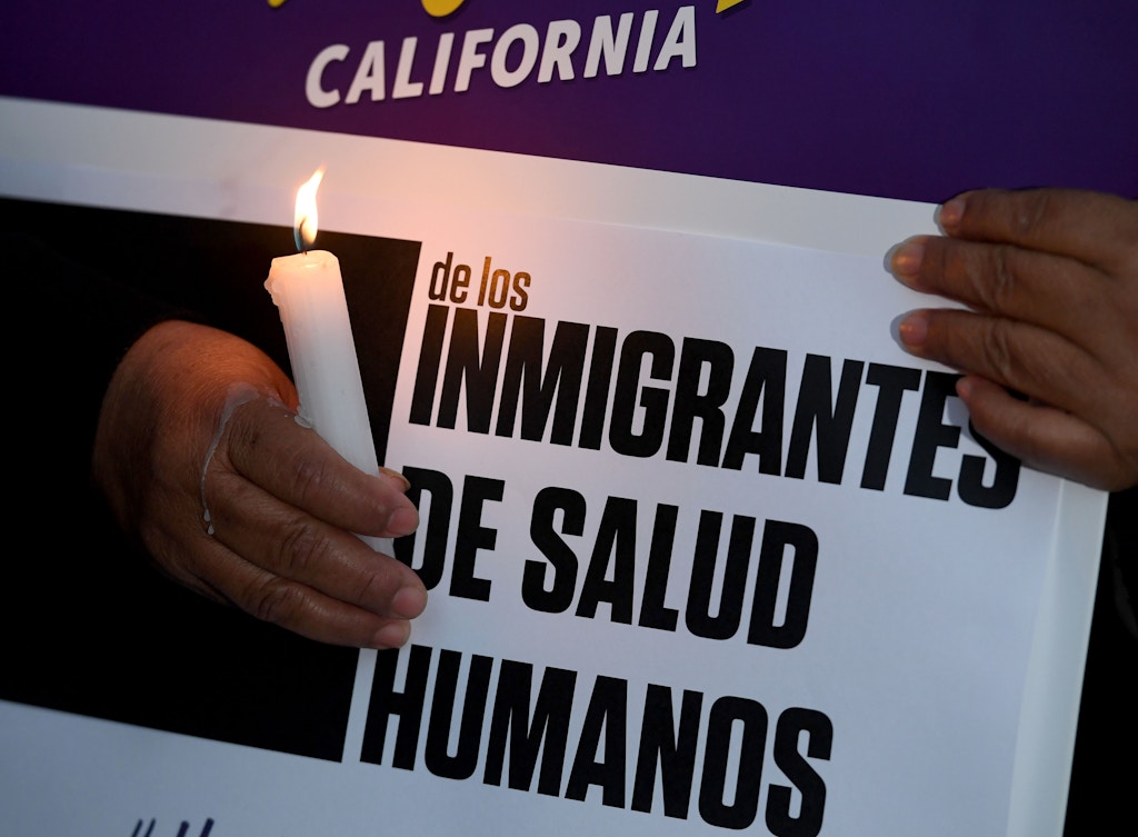Migrant rights groups hold candles during a vigil to protest against US President Donald Trump's new crackdown on "sanctuary cities", outside the City Hall in Los Angeles on January 25, 2017.Some 300 such cities, counties or states -- from New York to Los Angeles -- exist throughout the United States, and many of them have vowed since Trump's election to protect the estimated 11 million undocumented migrants living in the country. / AFP / Mark RALSTON (Photo credit should read MARK RALSTON/AFP/Getty Images)