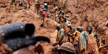 (FILES) This photo taken February 23, 2009 shows mining workers standing on a muddy cliff as they work at a gold mine in Chudja, near Bunia, north eastern Congo. Eighteen prospectors were killed overnight on August 19-20, 2009 in a diamond mine in central Democratic Republic of Congo, union officials said on August 20, 2009. Celestin Kubela, the head of the local mining authority in Kasai province, said that the victims, who were all illlegal miners, are thought to have touched a power cable deep underground. AFP PHOTO / LIONEL HEALING (Photo credit should read LIONEL HEALING/AFP/Getty Images)