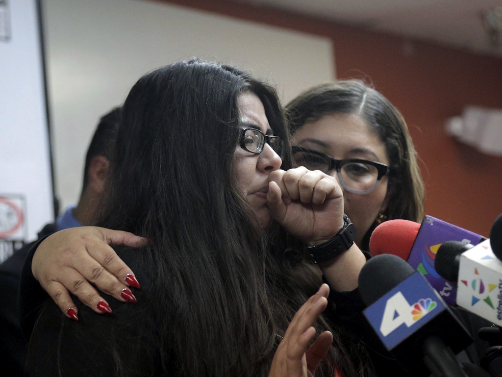 CLARIFIES THAT FATHER HAS NOT BEEN DEPORTED- Marlene Mosqueda, left, who's father was arrested by ICE early Friday morning to be deported, is comforted at a news conference by her attorney Karla Navarrette at The Coalition for Humane Immigrant Rights of Los Angeles (CHIRLA) on Friday, Feb. 10, 2017. Navarrete, said she sought to stop Mosqueda from being placed on a bus to Mexico and was told by ICE that things had changed. She said another lawyer filed federal court papers to halt his removal. (AP Photo/Nick Ut)